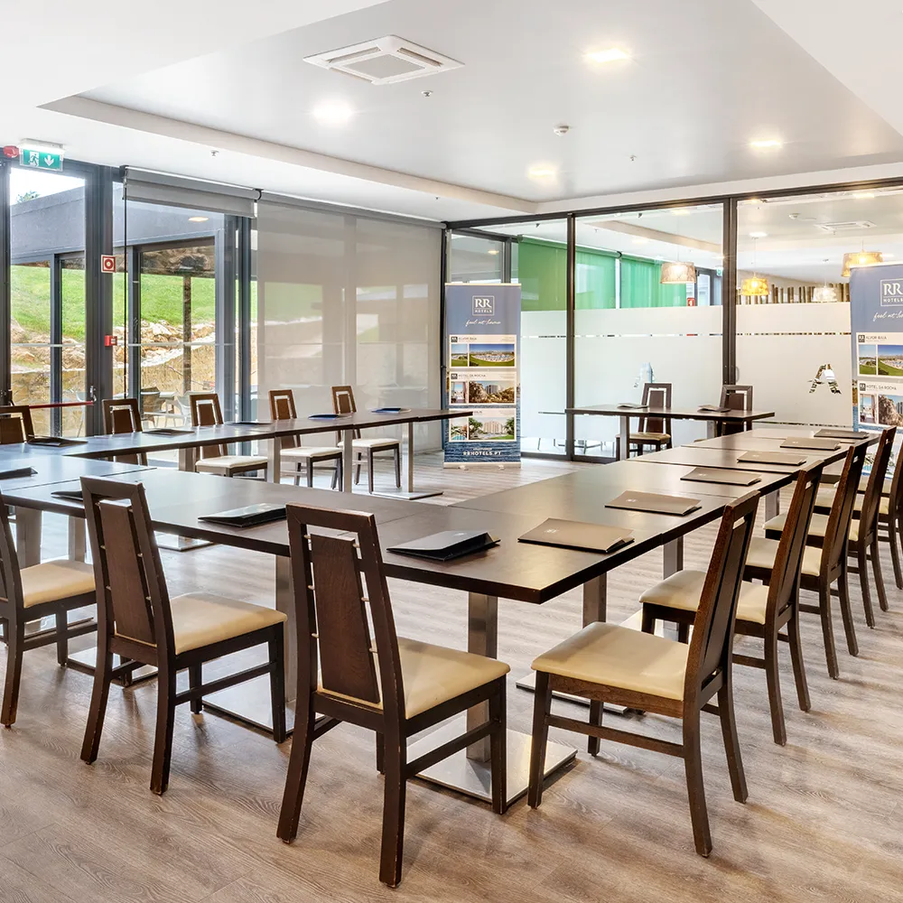 Meeting room at Alvor Baía Resort Hotel set with tables and chairs for events and meetings.
