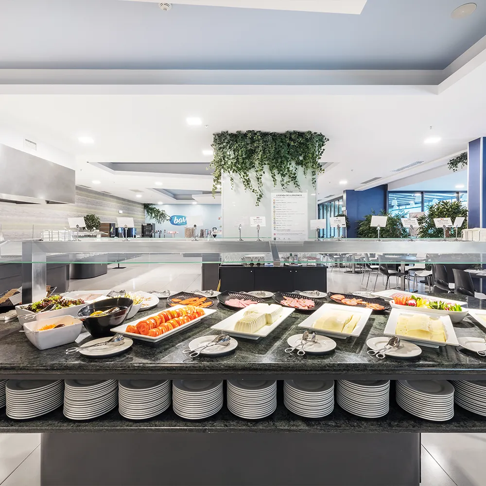 Seleção de pratos frios, queijos, tomate e outros acompanhamentos no buffet de pequeno-almoço do restaurante.
