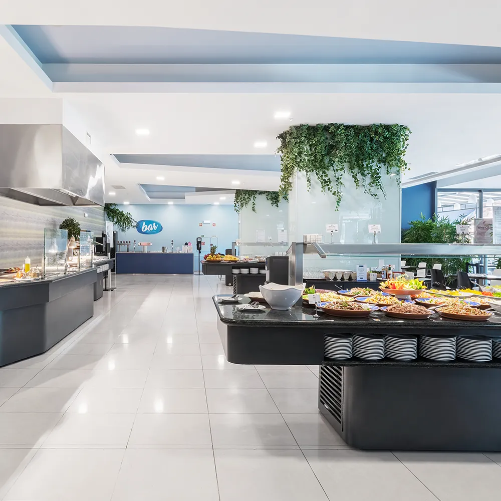 Vista ampla do buffet do restaurante Blue com diferentes estações de comida e opções para os hóspedes.