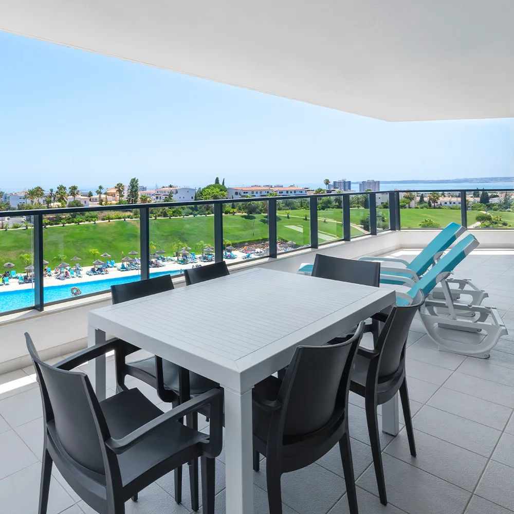 Varanda panorâmica da Suite Club do Alvor Baía com espreguiçadeiras e vista sobre o resort.