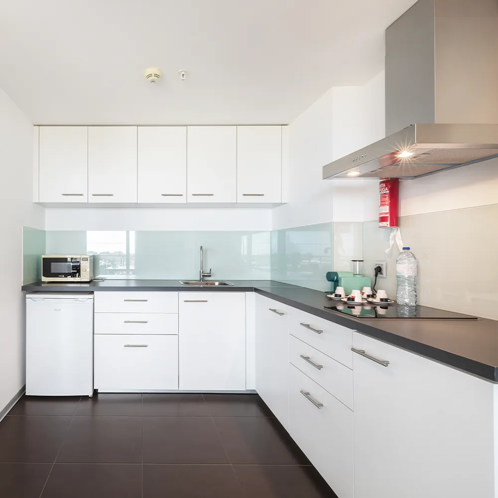 Kitchenette da Suite Club do Alvor Baía com máquina de café, micro-ondas, frigorífico e bancada equipada.