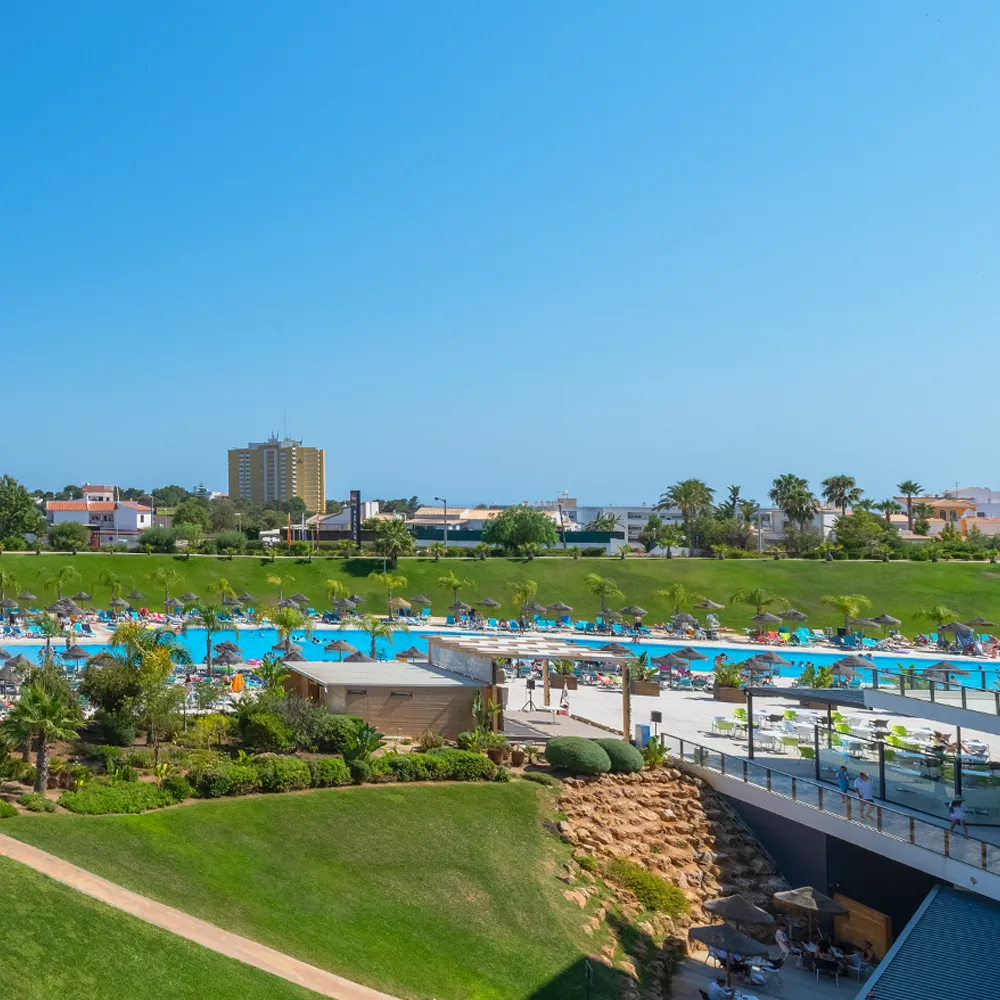 Varanda da Suite Prestige do Alvor Baía com vista sobre a piscina e jardim.