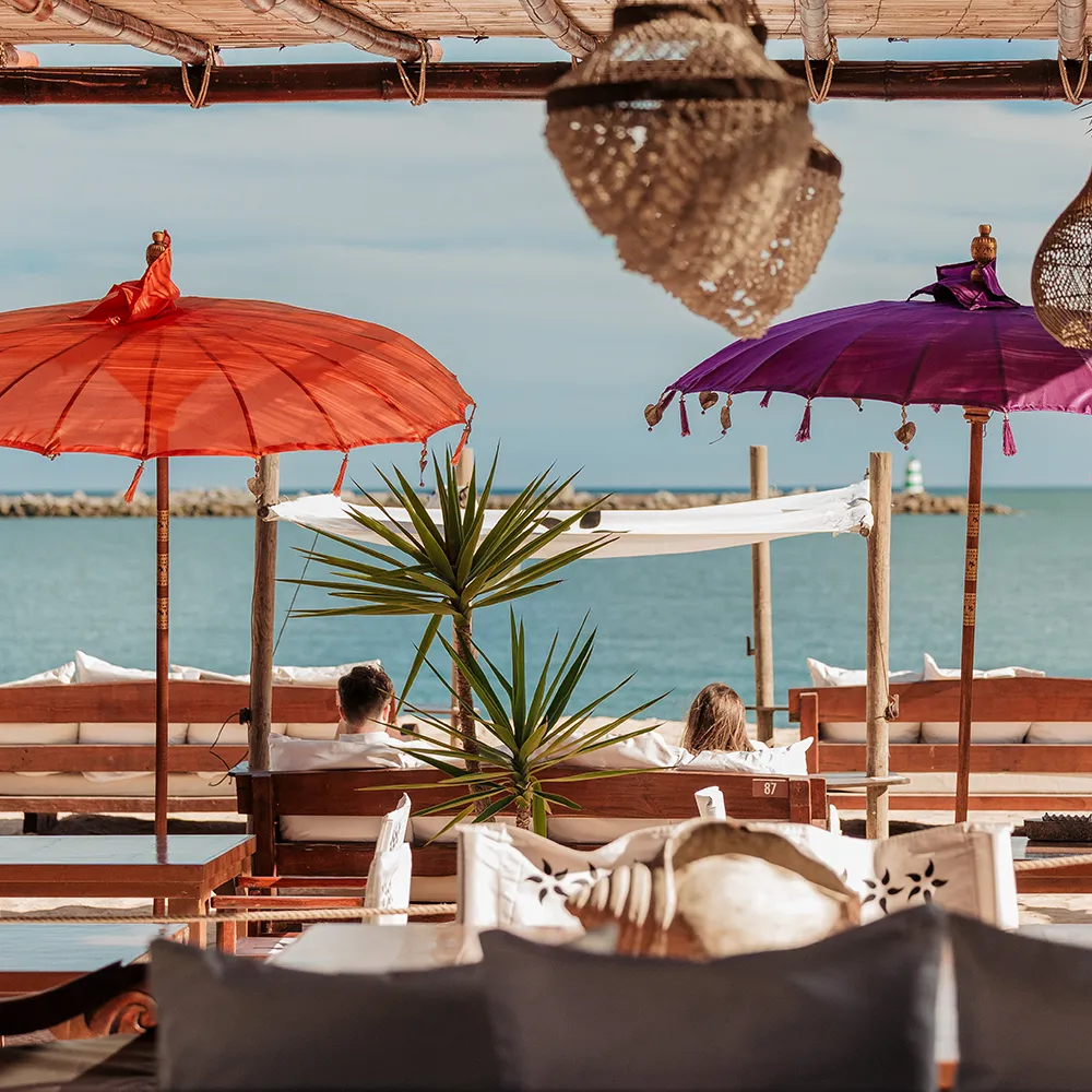 Beach lounge with Balinese daybeds and parasols at NoSoloÁgua Beach Club.