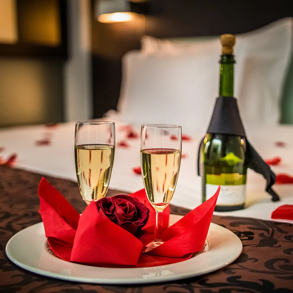 Romantisch dekorierte Suite mit Sekt und Rosenblättern