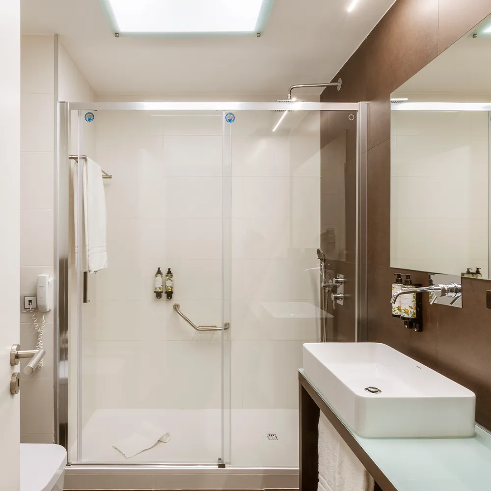 Casa de banho da Suite Suntset do RR Hotel da Rocha com poliban, rain shower e amenities Castelbel.